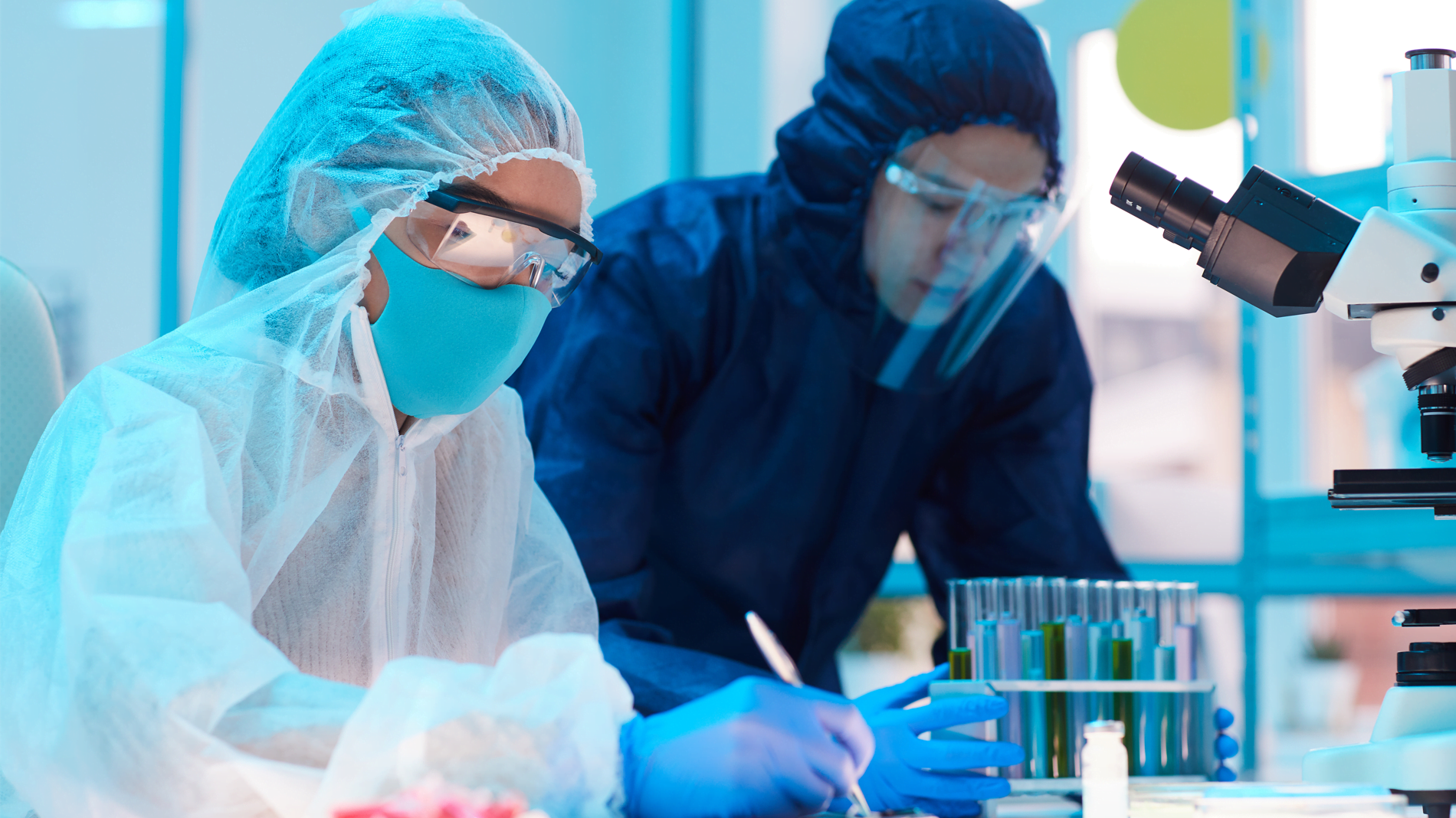 Duas mulheres com equipamento anti-contaminação realizando uma validação de limpeza